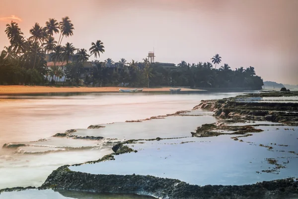 Sri Lanka. Beruwela. Koraalriffen in de buurt van de kust met palmbomen in de ochtend — Stockfoto