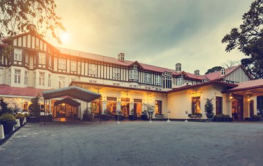 Nuwara Eliya, Sri Lanka'da Elizabeth döneminden kalma bir malikane tarzında inşa edilmiş batan güneşin ışığında Grand otel akşamı