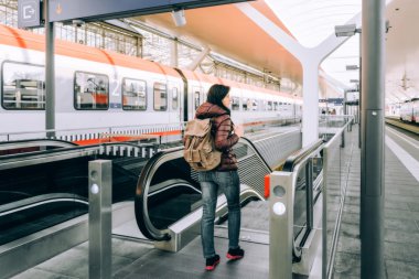 Alp demiryolu, tren ile seyahat. Kız yürüyen gelen tren istasyonu platformu