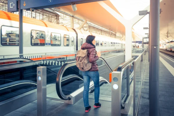 Alp demiryolu, tren ile seyahat. Kız yürüyen gelen tren istasyonu platformu.