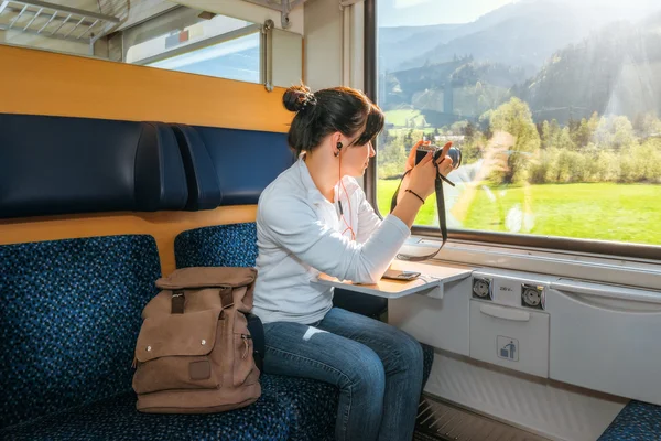  Kadın gezgin bir tren penceresinden fotoğraflandı. Windows güzel görünümler.