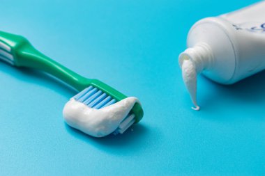 Mavi arka planda diş fırçası ve diş macunu. Diş sağlığı konsepti.