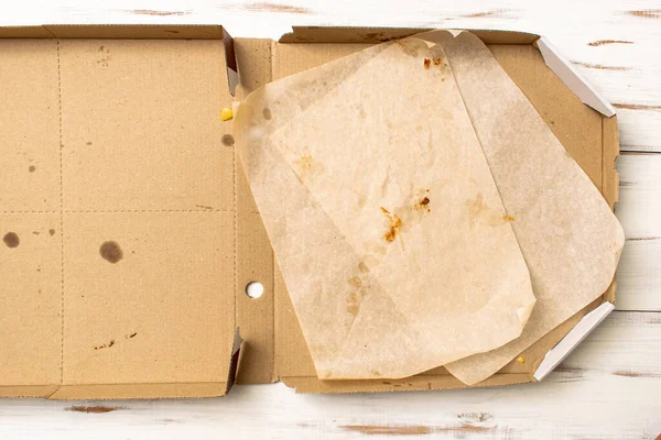 Empty pizza box on a wooden background.