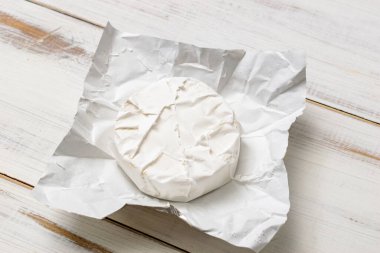 Ahşap arka planda yuvarlak peynirli Camembert peyniri..