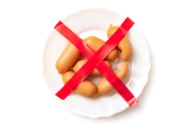 Reddetme, sosis yeme yasağı, sosis. Beyaz arka planda tabakta üstü çizilmiş sosisler..