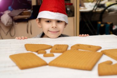 Çocuk zencefilli kurabiye evi yapıyor. Tatil hazırlığı, yaratıcı aktivite.