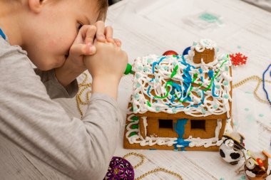 Çocuk zencefilli kurabiye evi yapıyor. Tatil hazırlığı, yaratıcı aktivite.