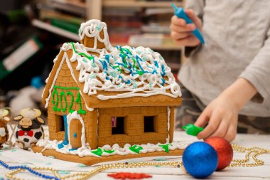 Çocuk zencefilli kurabiye evi yapıyor. Tatil hazırlığı, yaratıcı aktivite.