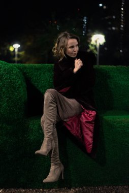 Orta yaşlı bir kadın geceleri karanlık bir parkta oturuyor..