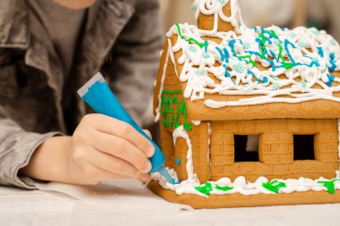 Çocuk zencefilli kurabiye evi yapıyor. Tatil hazırlığı, yaratıcı aktivite.