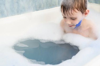 Köpük banyosundaki bebeğe mavi boya bulaşmış. Çocuk oyunları, eğlence..