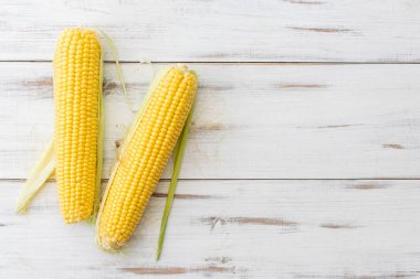 Beyaz ahşap arka planda tam mısır. Vejetaryen yemeği..