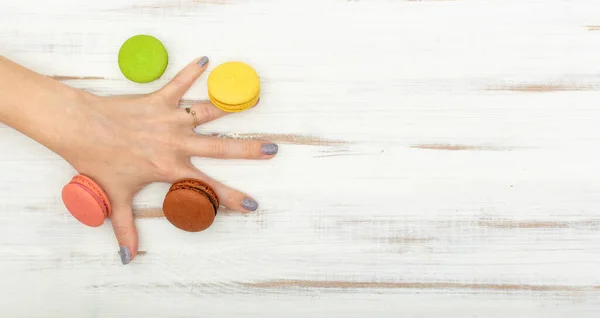 Pastel Macarrones Una Mano Femenina Sobre Fondo Madera Blanco —  Fotos de Stock