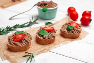 Tavuk ciğeri ezmesi. Sandviçler, beyaz ahşap arka planda vişneli domatesli kanepeler..