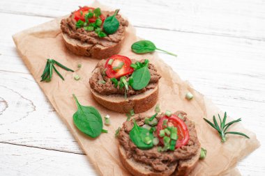 Sandviç, tavuk etli kanepe, domates. Beyaz ahşap arka planda.