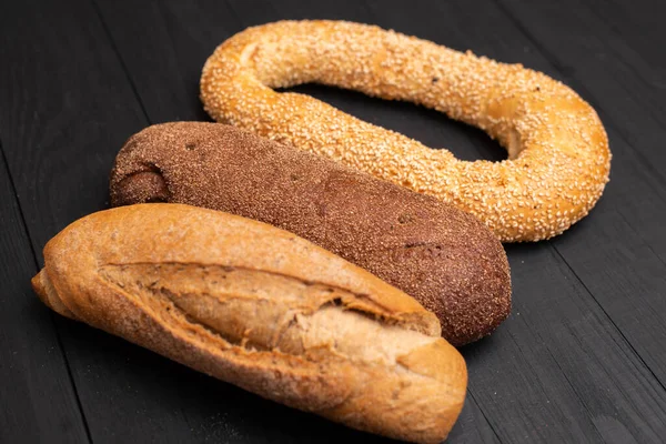 黒の背景に異なる種類のパン — ストック写真