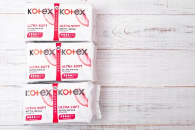Kiev, Ukrayna, -13 Aralık 2020: Beyaz ahşap arka planda Kotex hijyenik pedlerle paketler. Kadın hijyen ürünleri..