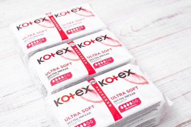 Kiev, Ukrayna, -13 Aralık 2020: Beyaz ahşap arka planda Kotex hijyenik pedlerle paketler. Kadın hijyen ürünleri..