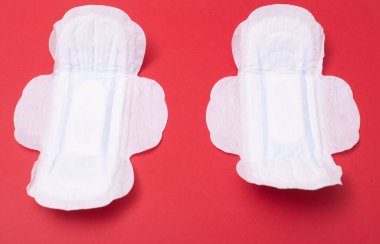 Kırmızı arka planda dişi pedi. Regl için hijyen ürünü.