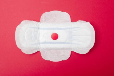 Kırmızı arka planda dişi pedi. Regl için hijyen ürünü.