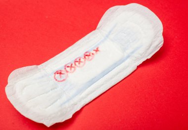 Kırmızı arka planda dişi pedi. Regl için hijyen ürünü.