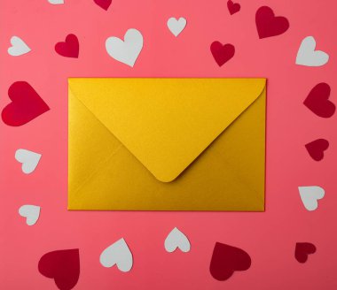 Aşk mektubu. Kırmızı arkaplanda altın bir zarf ve kalpler..