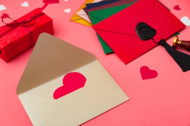 Aşk mektupları. Kırmızı arka planda kalpleri olan çok renkli zarflar..