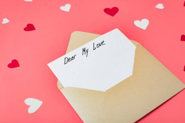Sevgili aşkım, mektubun başlangıcının metni. Kırmızı arka planda kalpleri olan bir zarf. Sevgililer Günü için ilan-ı aşk.