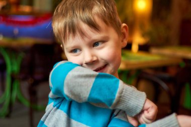 Gülümseyen küçük bir çocuğun yakın plan portresi.