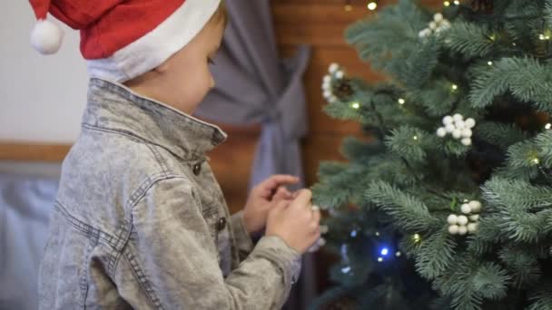 Ένα Νεαρό Αγόρι Στολίζει Ένα Χριστουγεννιάτικο Δέντρο — Αρχείο Βίντεο
