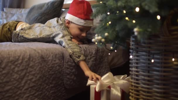 Αγόρι Φτάνει Για Ένα Δώρο Κάτω Από Δέντρο Της Πρωτοχρονιάς — Αρχείο Βίντεο