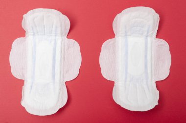 Kırmızı arka planda dişi pedi. Regl için hijyen ürünü.