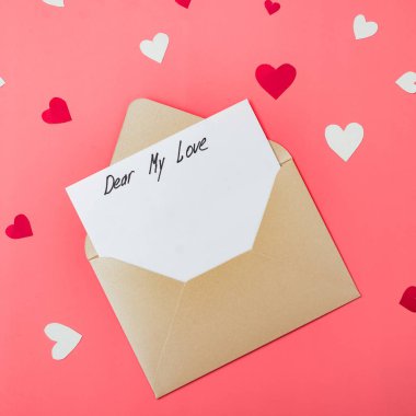 Sevgili aşkım, mektubun başlangıcının metni. Kırmızı arka planda kalpleri olan bir zarf. Sevgililer Günü için ilan-ı aşk.