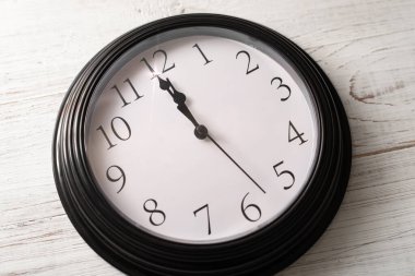 Beyaz bir arkaplanda saat. On ikiye bir var..