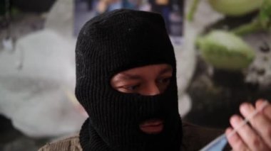 Hırsız maskesi takan bir adam tıbbi maske takmaya çalışır..