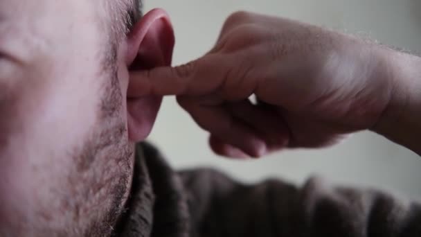 不安定な男が指で耳を選ぶ — ストック動画
