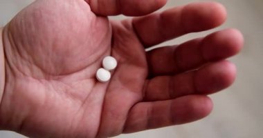 Bir adamın avucuna iki hap. İlaç, bağımlılık, tedavi kavramı.