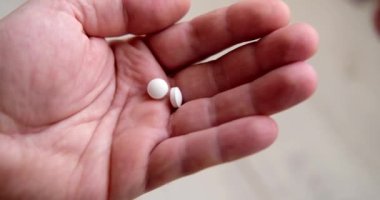 Son iki hap kutudan adamın avucuna düştü. İlaç, bağımlılık, tedavi kavramı.