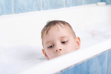 Genç bir çocuk köpükle banyo yapar. Çocuklar için kişisel temizlik.