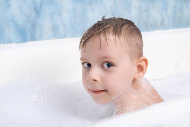 Genç bir çocuk köpükle banyo yapar. Çocuklar için kişisel temizlik.