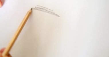 Kalem vuruşlarla kalp çizer. Beyaz bir kağıt üzerinde bir kalp şekli belirir..