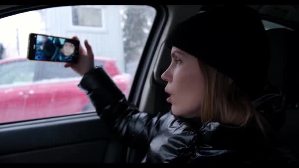 一位女性博客写手在车里写博客 在电话上拍摄自己 进行现场直播 — 图库视频影像