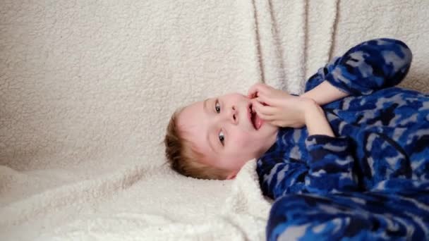 Νεαρό Αγόρι Γελάει Ενώ Βρίσκεται Στο Κρεβάτι — Αρχείο Βίντεο