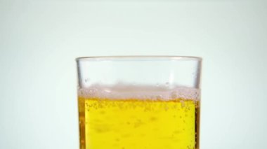 Bira beyaz arka planda bir bardağa dökülür..
