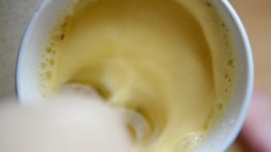 Karıştırıcıyla yumurta ve süt çırpıyor..