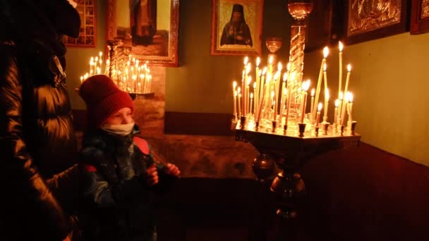 Niño Pone Una Vela Altar Una Iglesia Cristiana — Vídeo de stock