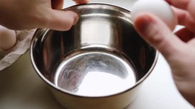 Tavuk yumurtaları bir kaseye kırılır. İkinci yumurtanın kabuğu yanlış bir şekilde kaseye düşer. Omlet pişiriyorum..