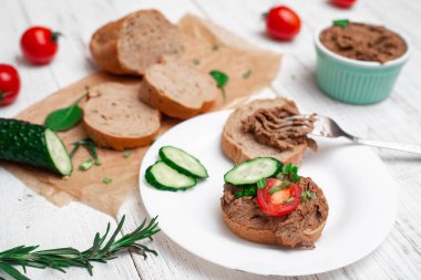 Sandviç, tavuk etli kanepe, domates ve salatalık. Beyaz ahşap arka planda.