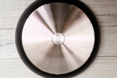 Beyaz ahşap arka planda yeni alüminyum kızartma tavasının alt tarafı..