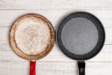 Tavaların karşılaştırılması. Eski ve yeni kızartma tavası. Yeni ve eski hasarlı yapışmaz kaplama.